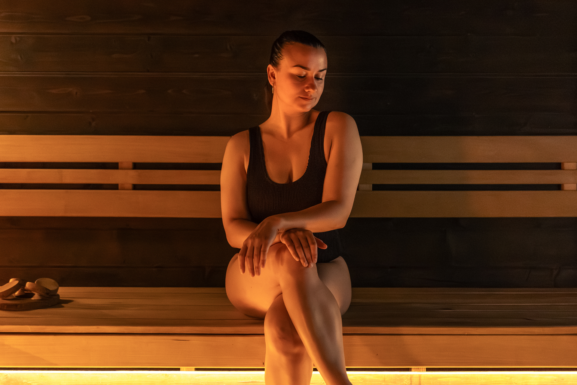 Woman seated peacefully in sauna enjoying contrast therapy benefits